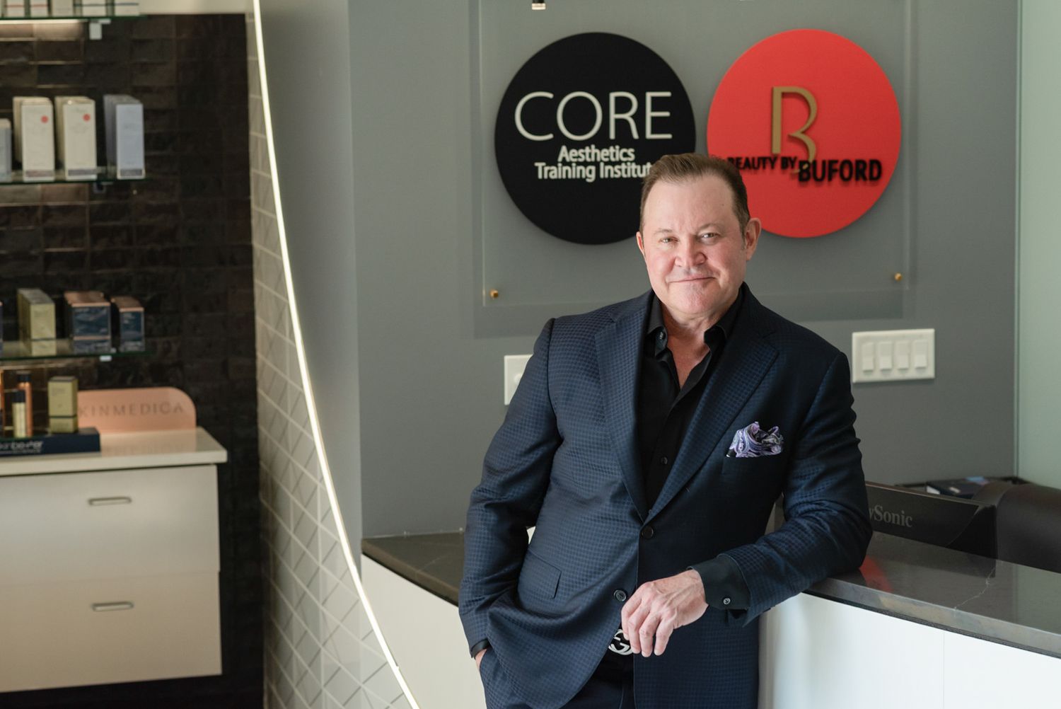 Man standing at aesthetics training institute reception.