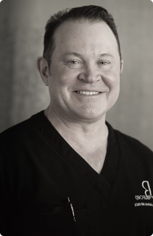 Thoughtful man in black attire, looking sideways.