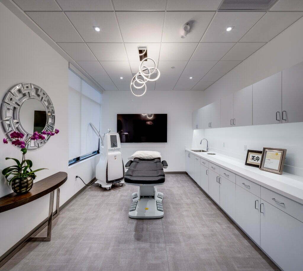 Modern medical treatment room with equipment and decor.