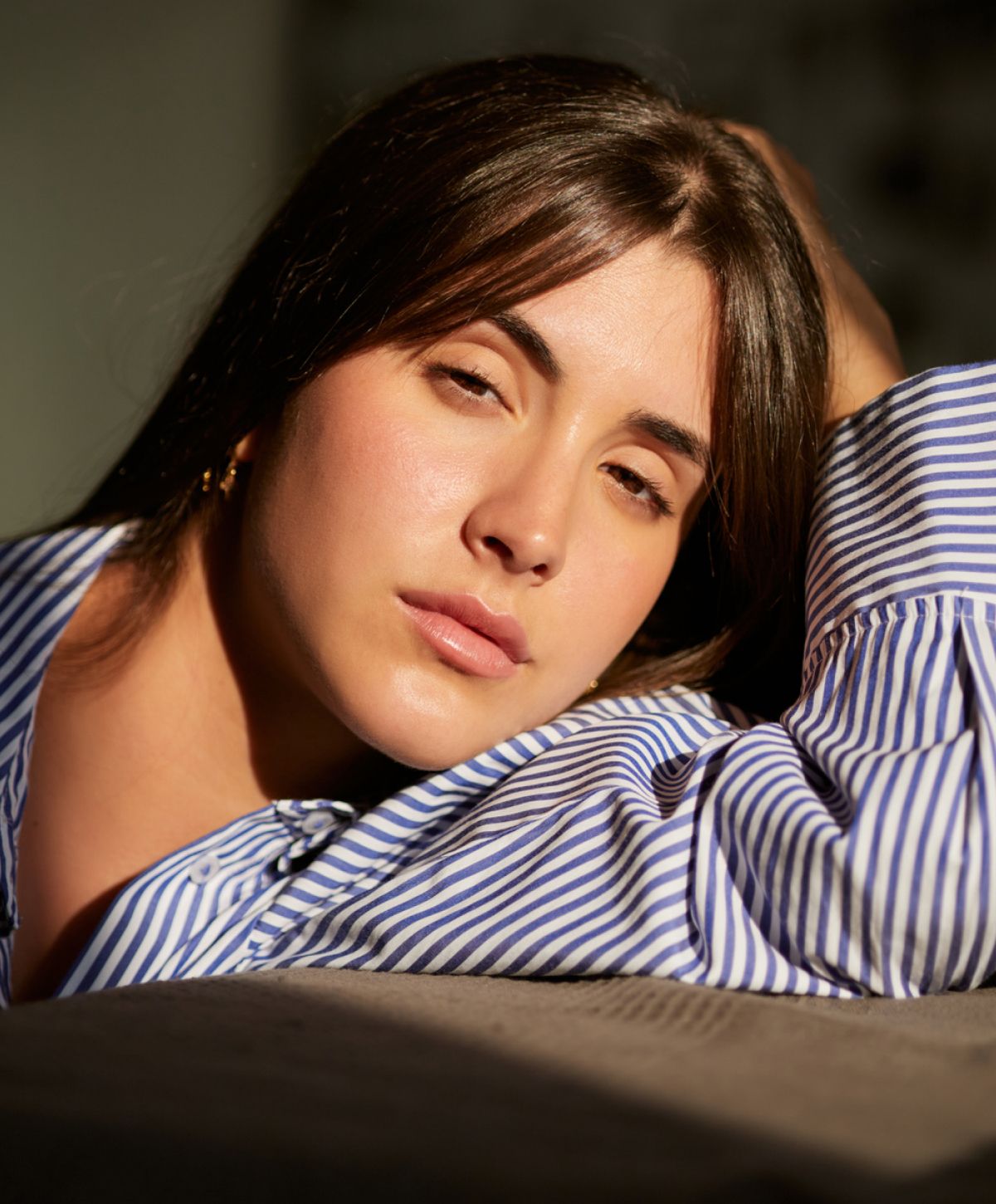 Woman in black bra gazing out window.