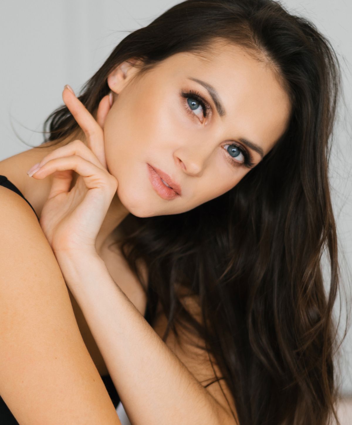 Woman with long hair posing thoughtfully.