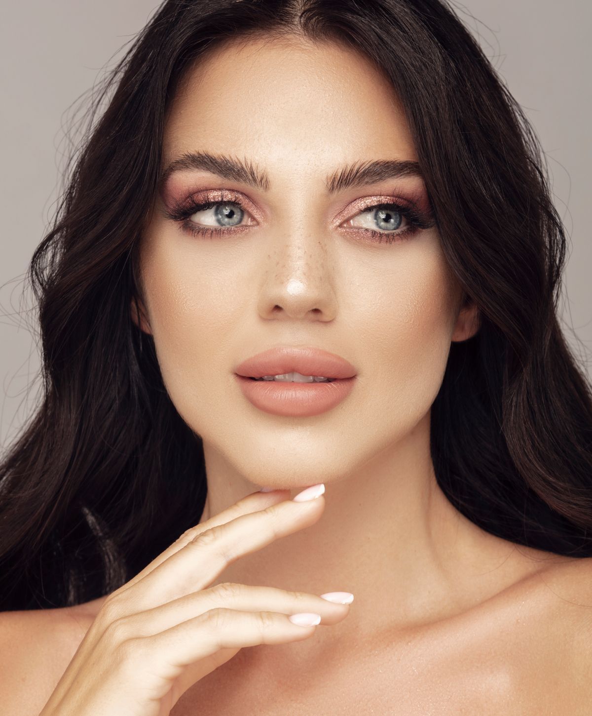 Woman with elegant earrings and soft makeup.