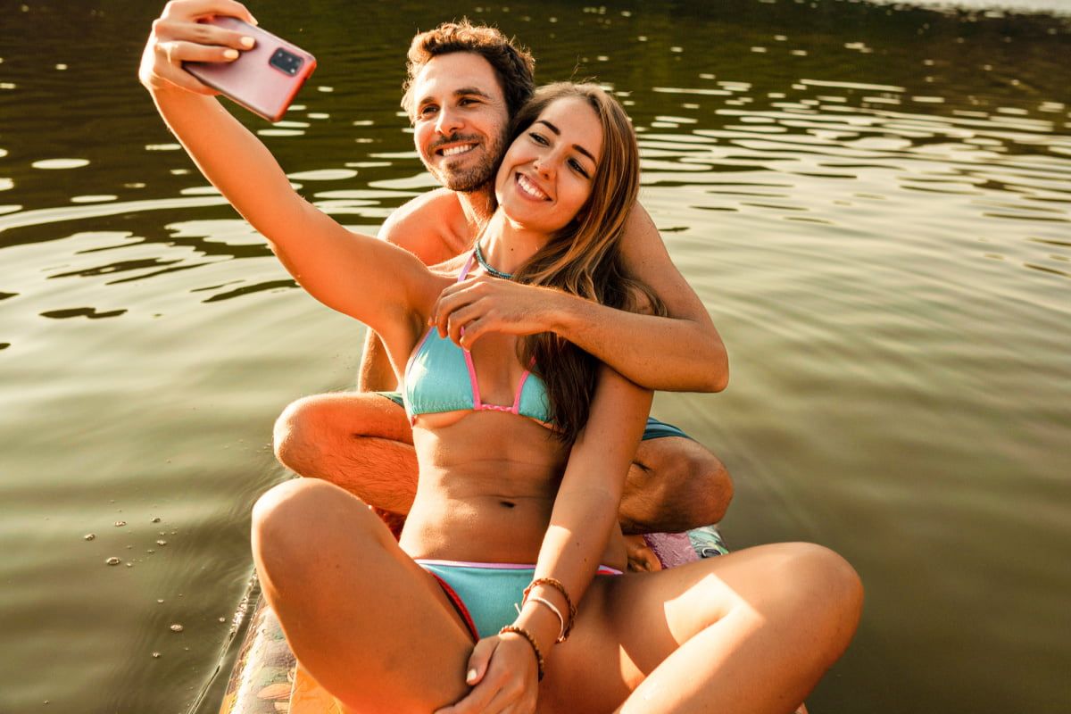 Couple taking a selfie on a lake.