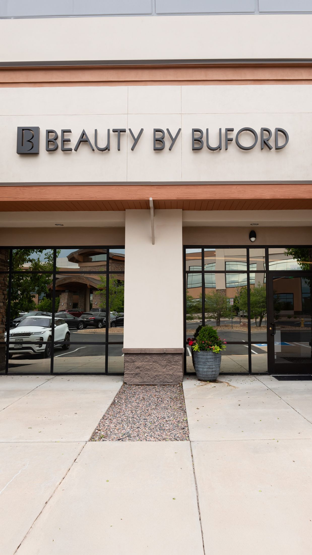 Beauty by Buford storefront with flower planter.